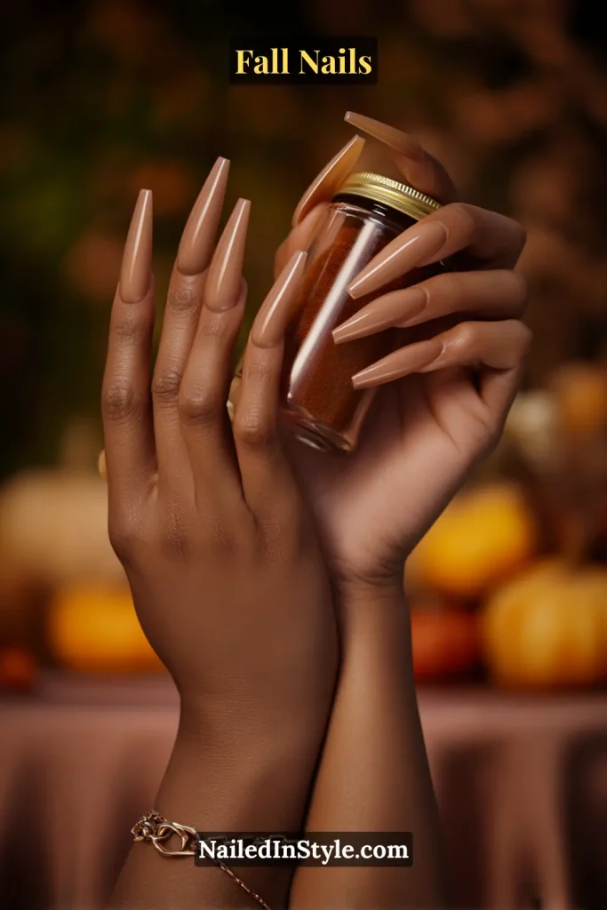 Coffin fall nails in Saffron Sheer with a weightless saffron tint over a neutral base, styled holding a fall spice jar.