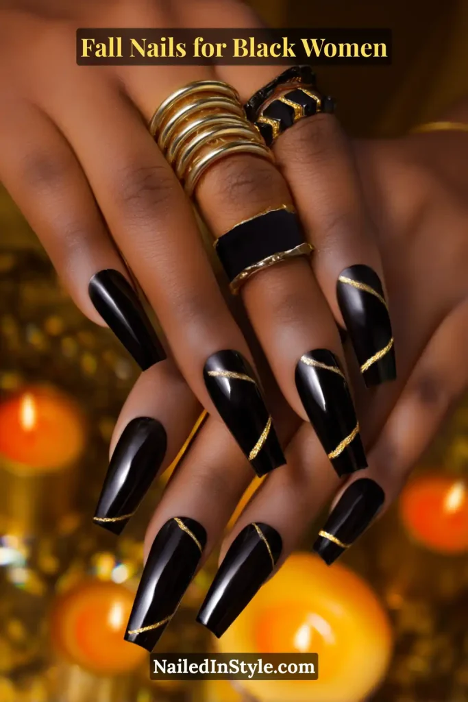 Fall nails for Black women featuring glossy black nails with gold line accents, styled with bold gold jewelry.