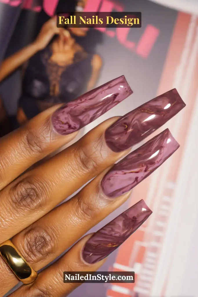 Fall Nails Design: Bold, Chic & Gorgeous Ideas 11 Fall nails design featuring plum coffin nails with taupe and plum marbled swirls, styled against a fashion magazine backdrop.