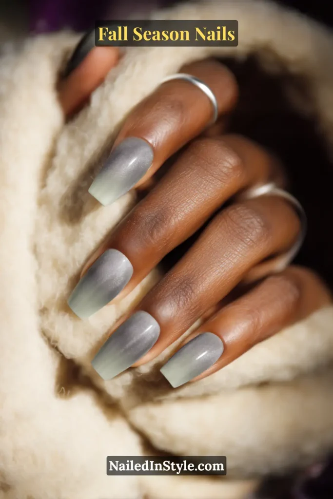 Smoky sage aura nails with pale green centers and soft halo edges, styled in window light on a wool scarf.