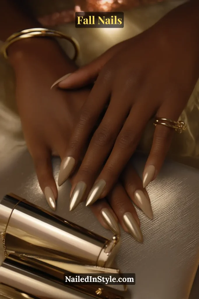 Stiletto fall nails in Brushed Brass French with soft brass tips and a subtle brushed finish, styled with gold clutch clasp.
