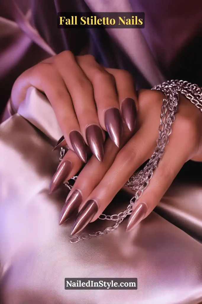 Fall Stiletto Nails Taupe-smoke stiletto nails with a magnetic cat-eye shimmer effect, styled on satin with silver chains.