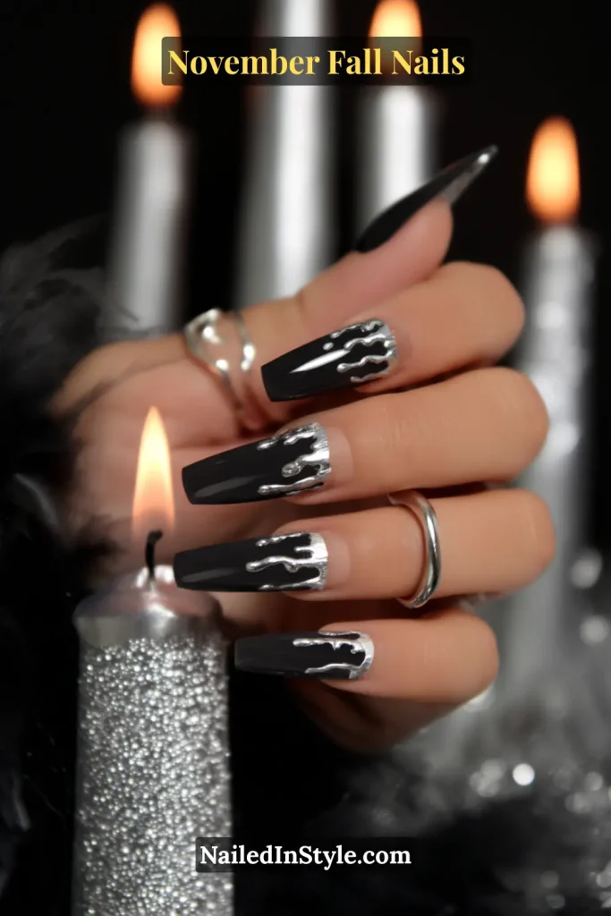 November fall nails with a blackened base and molten pewter drip art, styled beside a silver taper candle.