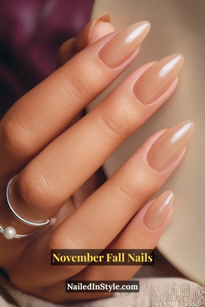 November fall nails in sheer latte nude with a glossy jelly finish, styled against a ceramic brunch plate.