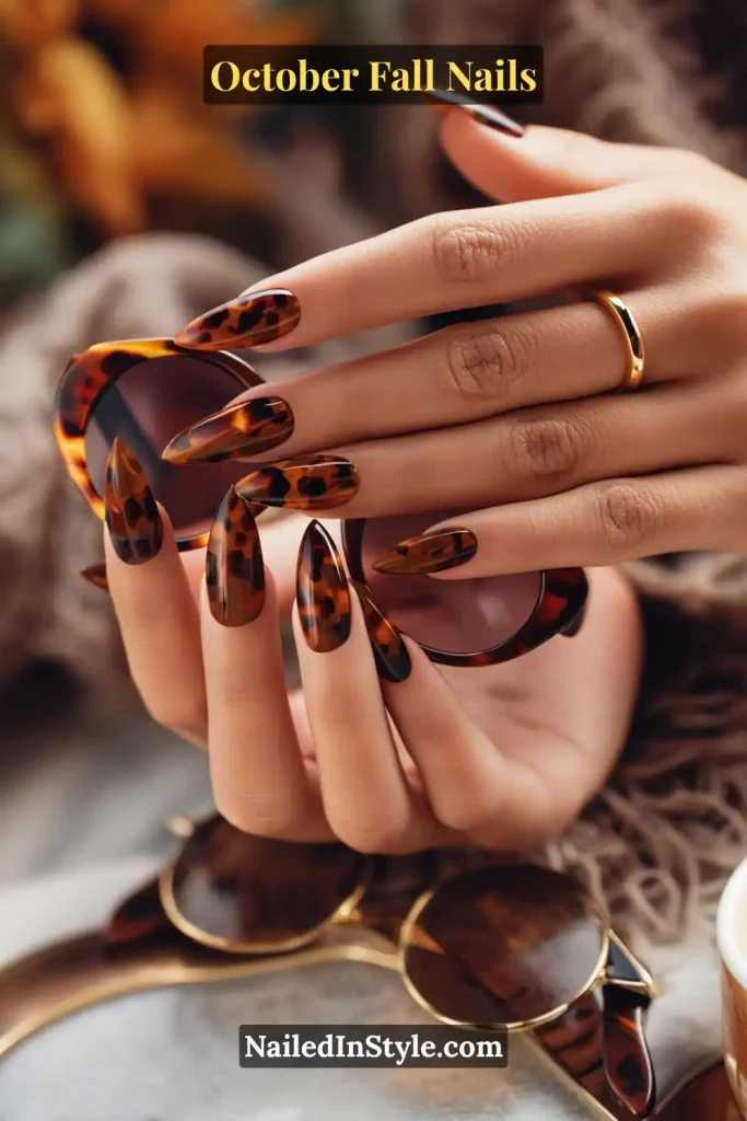 October fall nails with a scaled-down tortoiseshell design in chestnut and cocoa tones, styled over tortoiseshell sunglasses for a chic fall look.