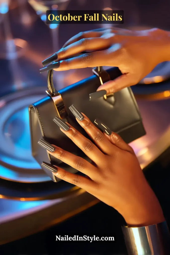 October fall nails in a charcoal base with ultrathin pewter pinstripe accents, long square shape, styled while holding a structured mini bag.
