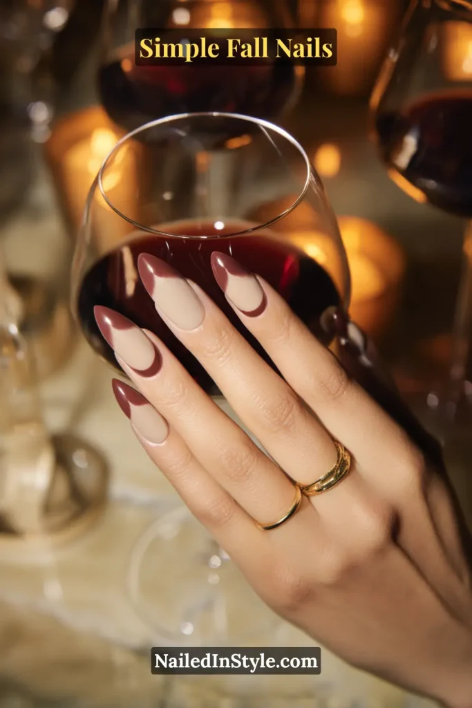Simple fall nails with a nude-to–fig-wine ombré fade in almond shape, styled during a wine toast moment with candlelight glow.