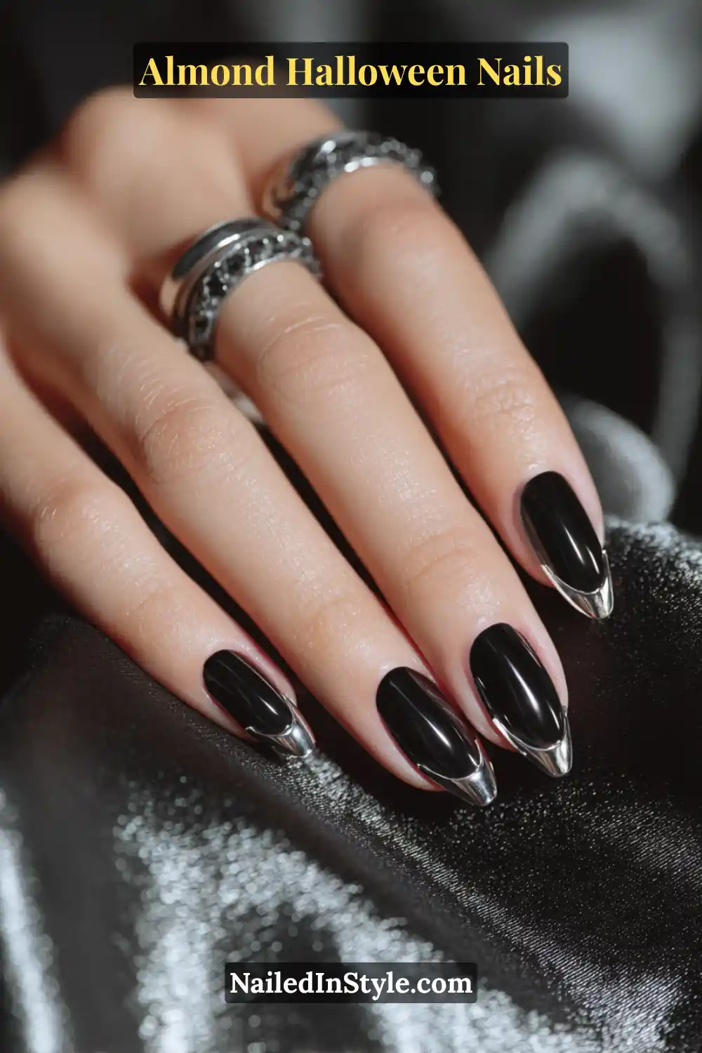 Close-up almond nails with transparent base framed by sculpted silver chrome fang tips, high-shine metallic finish, reflecting light on sleek edges, Almond Halloween Nails.