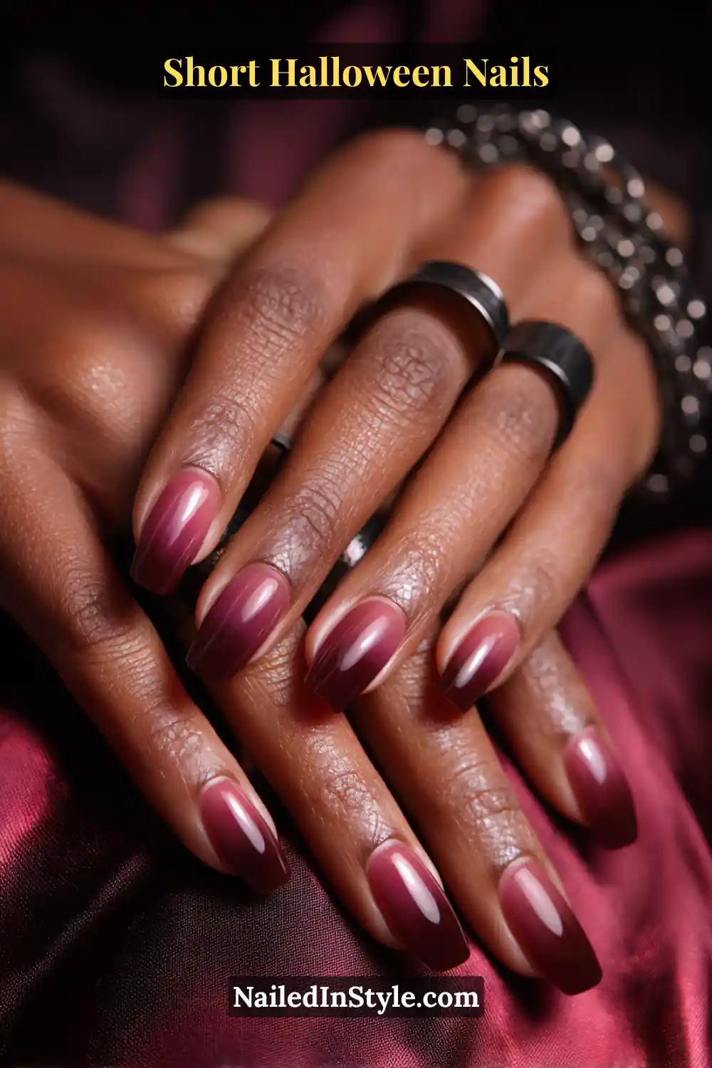 Short Halloween Nails Short square nails with a soft black-cherry gradient tip fading inward 1–2 mm, glossy gradient finish; styled with matte black rings and deep wine satin fabric, elegant Halloween nails for medium, olive, and deep skin tones.