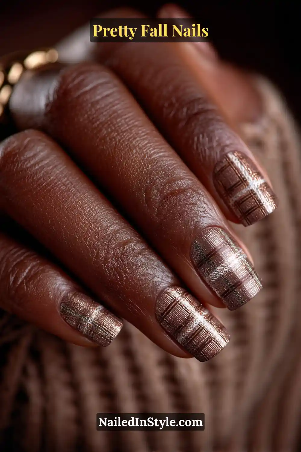 Short squoval nails detailed with soft-focus plaid lines in truffle and charcoal, intersected by metallic bronze threads that shimmer warmly against deep autumn skin for an elegant, woven effect.
