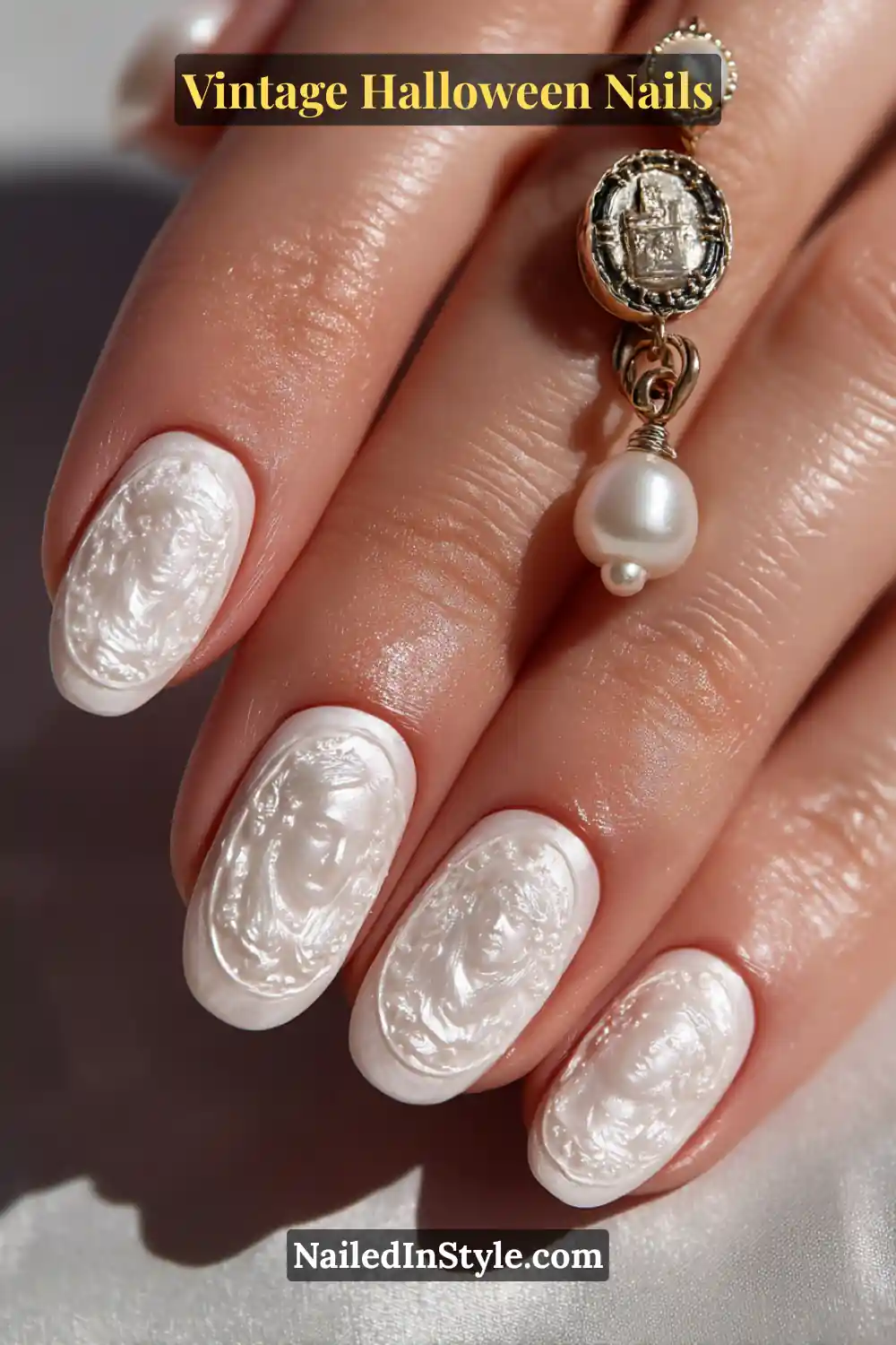 Medium oval nails in glossy porcelain white with embossed cameo faces framed in graphite gel — a sculpted 3D effect evoking antique jewelry for an elegant vintage Halloween vibe.