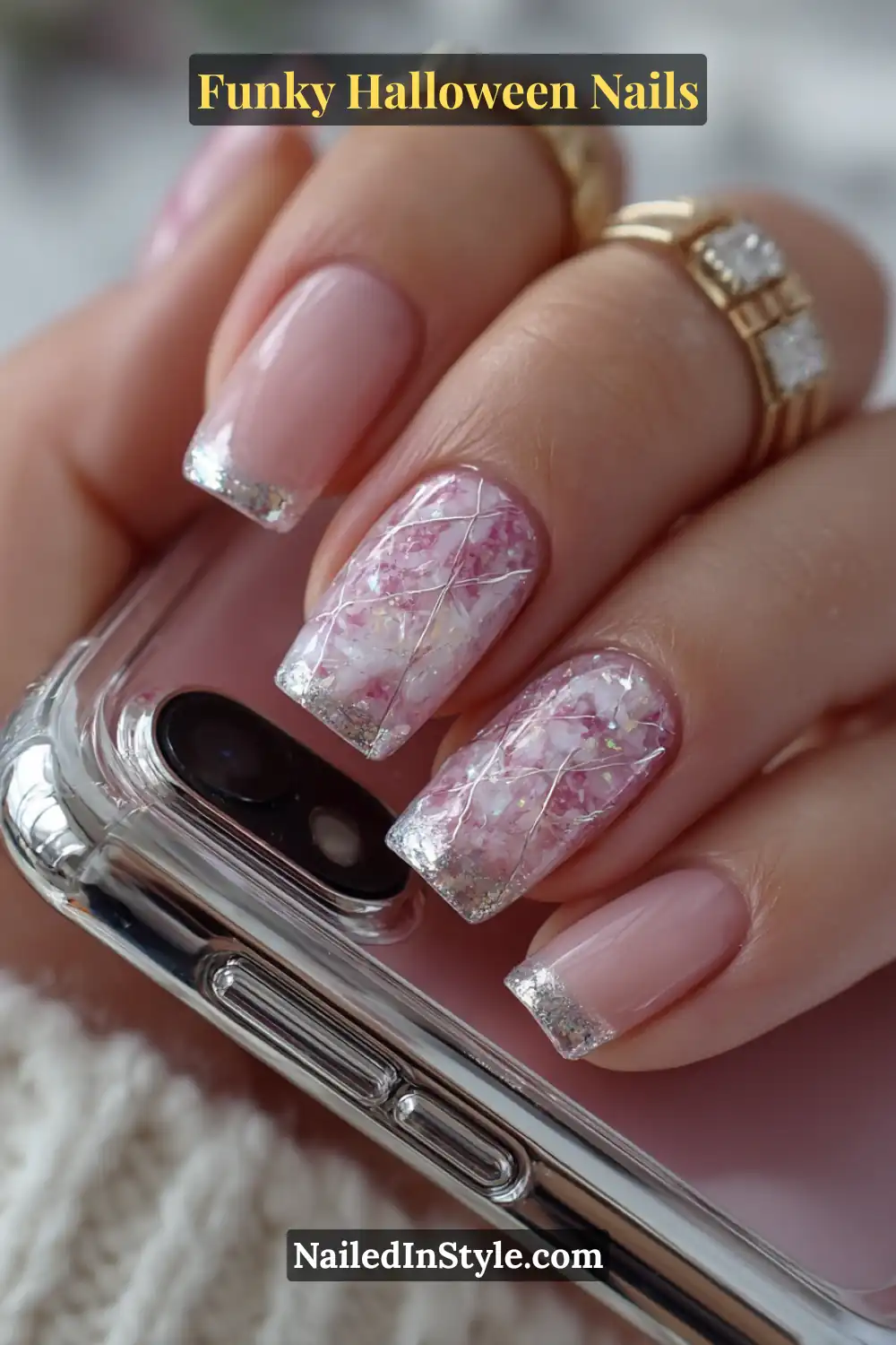 Short squoval nails in pink, lilac, and silver tones with a candy-glazed base and delicate silver thread web overlay in 3D texture, styled with a metallic phone case for a chic Halloween look.