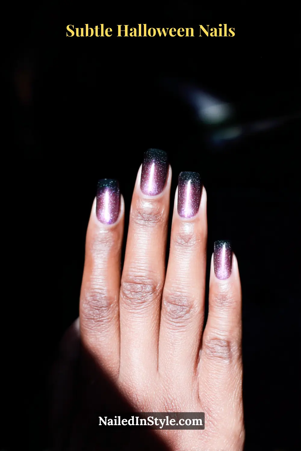 Medium almond nails with a magnetic cat-eye beam glowing in soft violet over a charcoal base, creating an illuminated depth that shifts with movement. Perfect for medium to deep skin tones and styled with a gem-tone clutch for moody elegance.