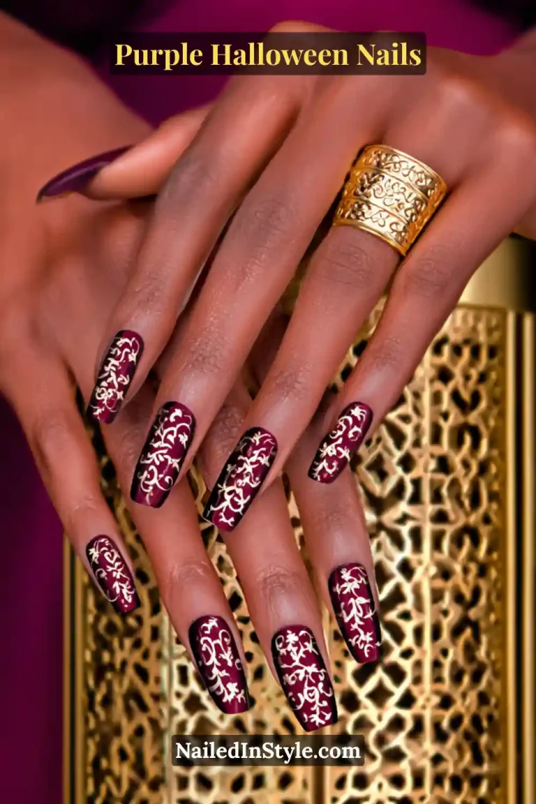 Medium oval nails in a deep wine satin base adorned with gold filigree patterns, creating a luxurious and regal Halloween nail design.