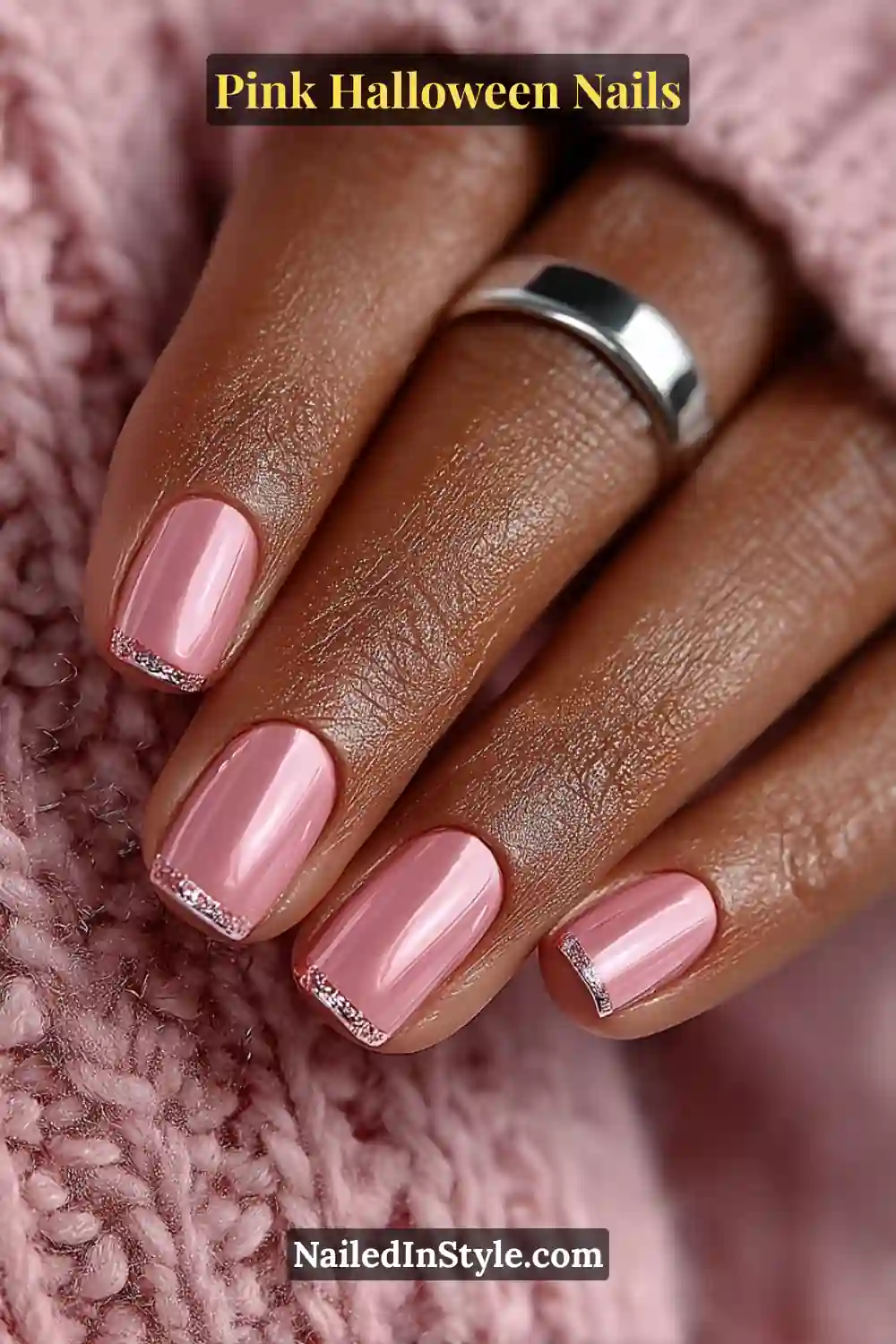 Pink Halloween nails with a soft blush base and razor-thin chrome cuff on medium square nails, paired with a steel band ring and cozy knit styling.