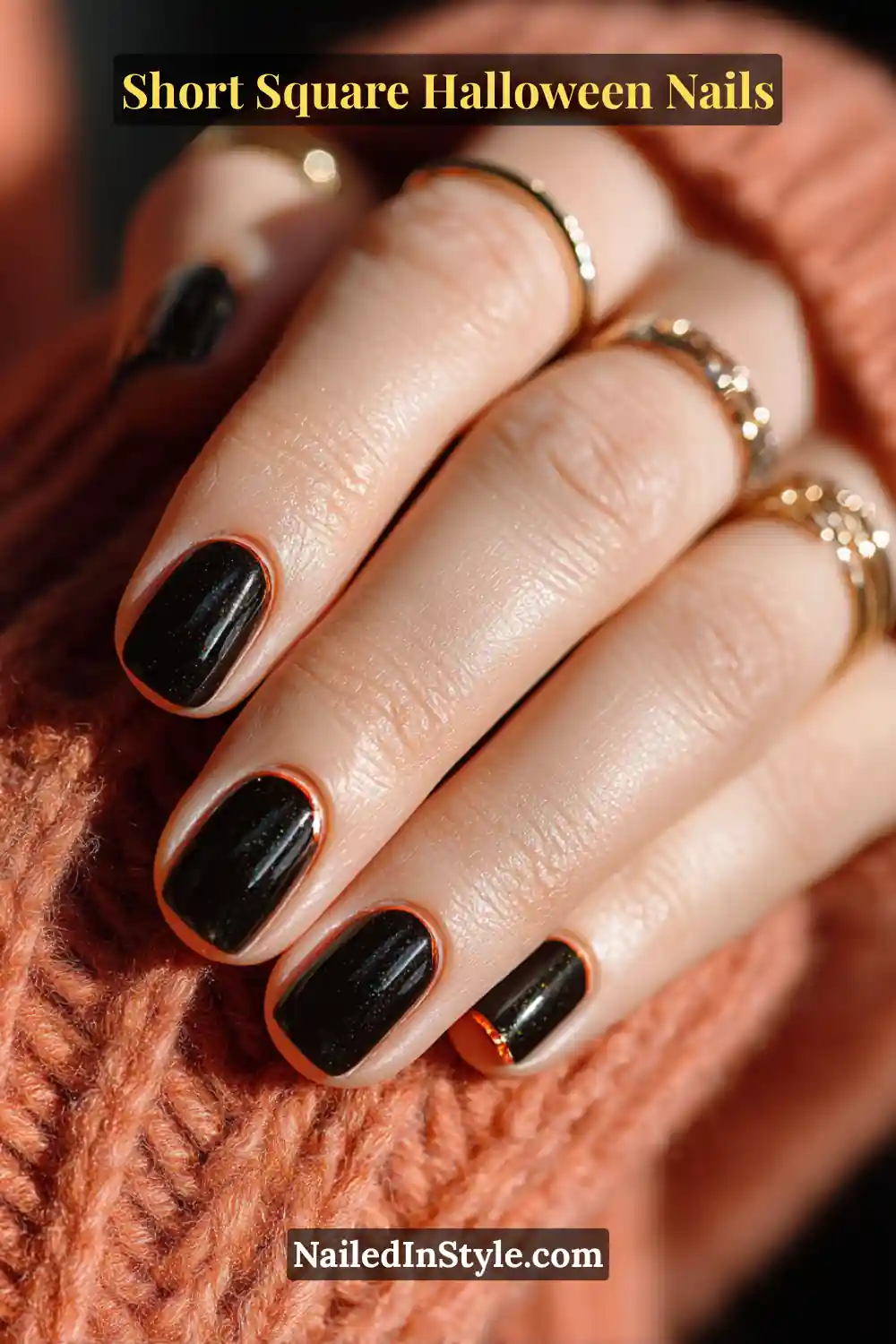 Short square nails painted in soft black with ember orange accents, detailed with small 3D domes for a glowing Halloween-inspired finish.