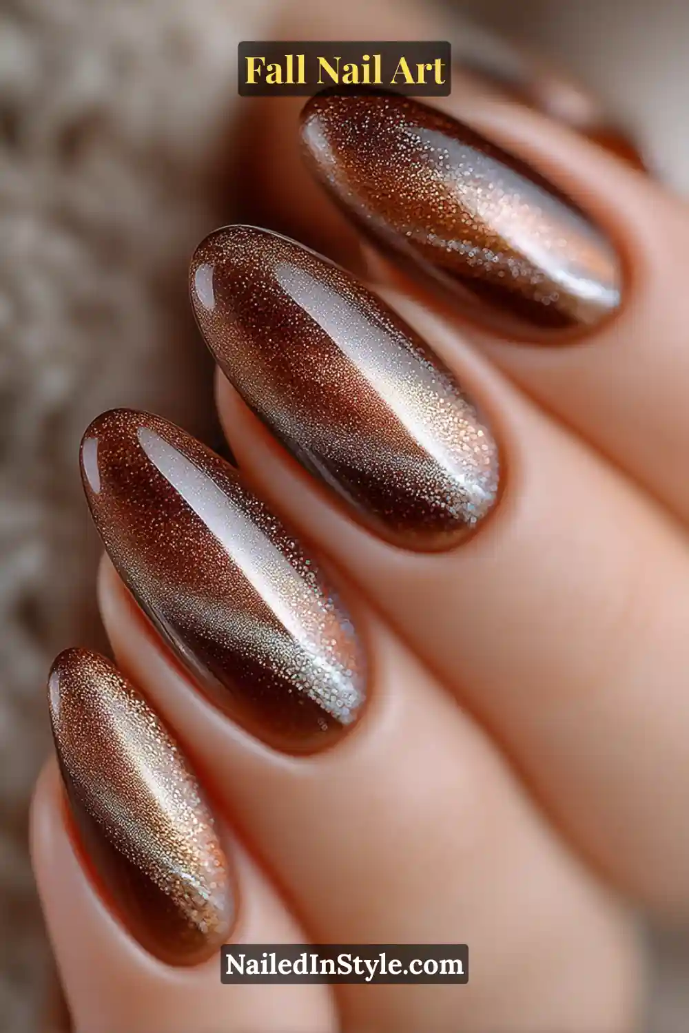 Long oval nails in cinnamon and cocoa hues with a magnetic silver cat-eye beam curving diagonally across each nail, creating an illuminated depth effect perfect for evening light.
