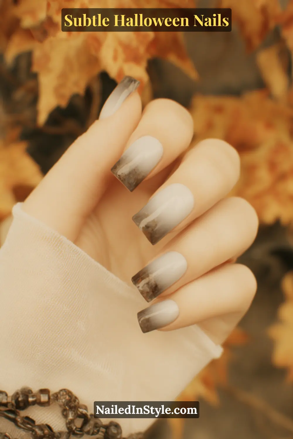 Medium almond nails with a misted ombré fade from soft porcelain to smoky gray, creating a marble-like veil of quartz tones that blend seamlessly for an ethereal Halloween look. Styled with a sheer silk sleeve for a touch of ghostly elegance.