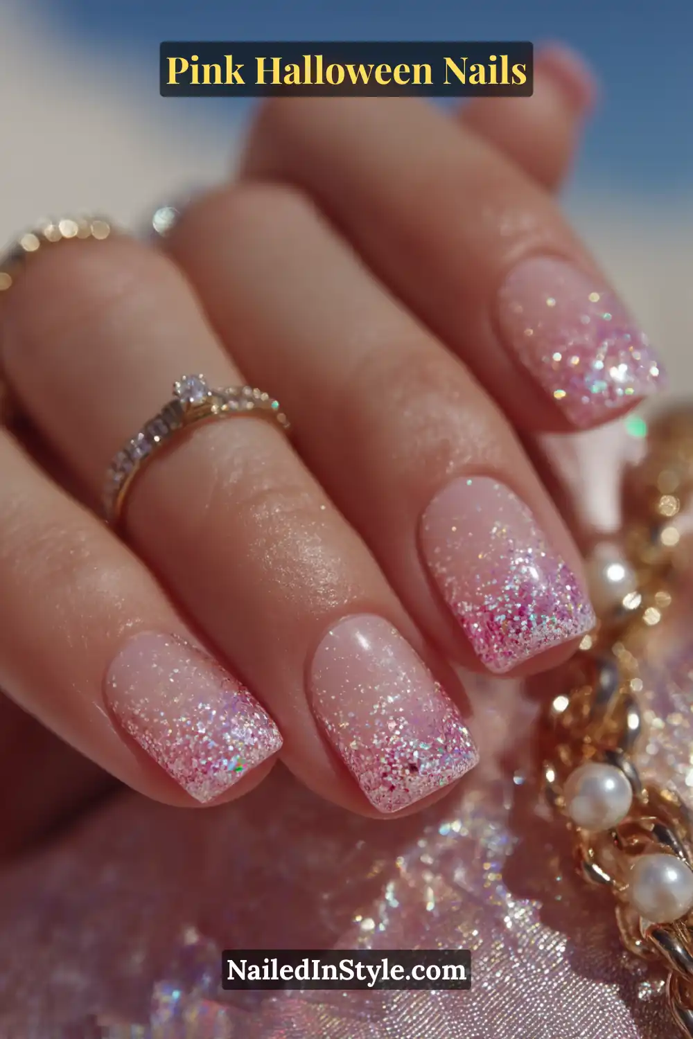 Pink Halloween nails with a clear-to-pink gradient and multicolor micro glitter dip effect, short round shape, sparkling under sunlight with a gold pearl bracelet.