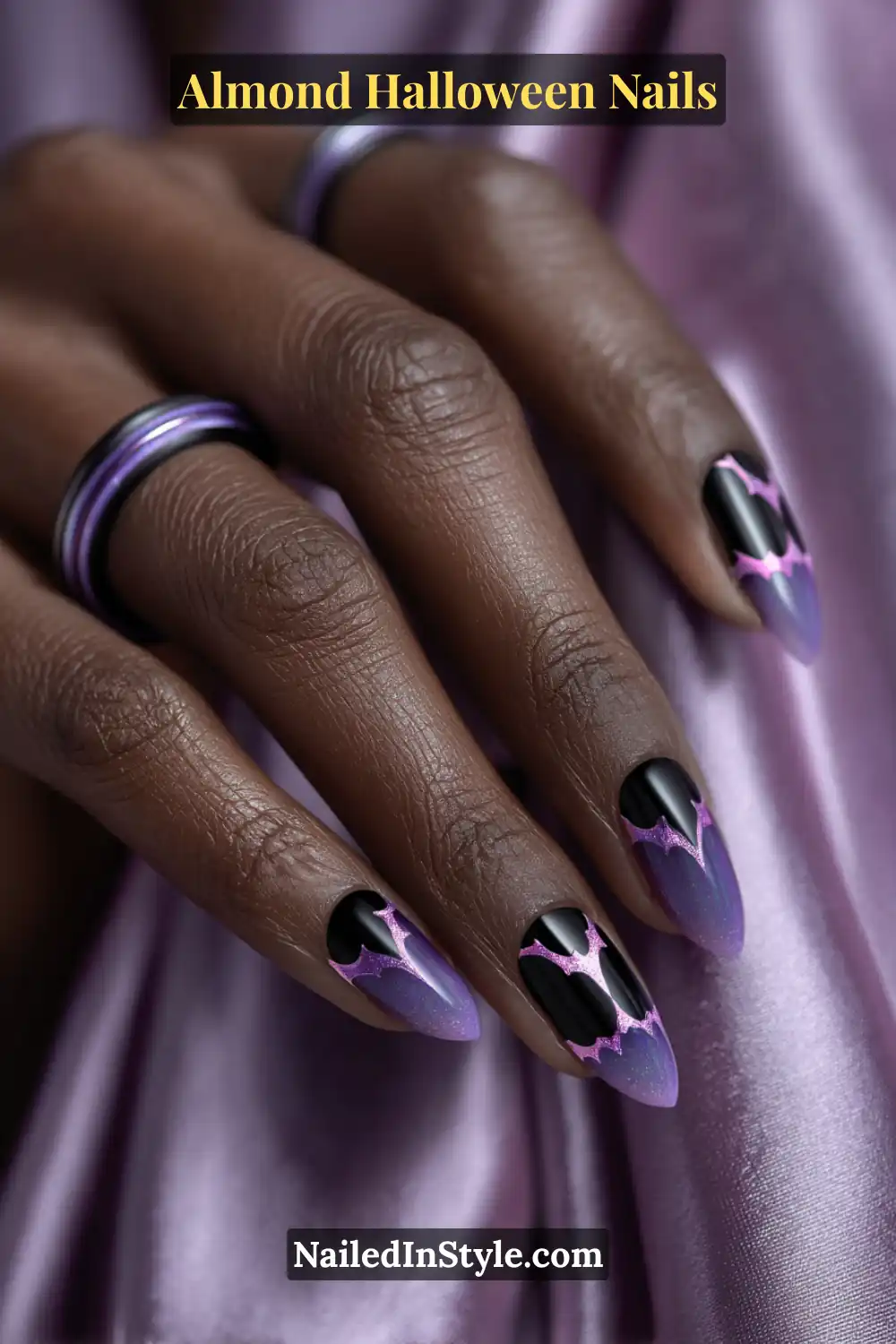 Almond Halloween Nails Close-up almond nails with black chrome bat shapes edged in neon purple glow, glossy gradient finish fading into lilac tips, Almond Halloween Nails.