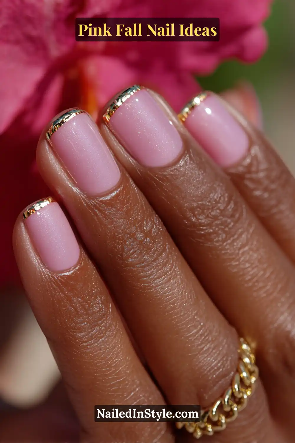 Pink Fall Nail Ideas: Chic, Fast & Photogenic 2025 13 Short square nails in glossy flamingo pink with a fine metallic gold French tip, glowing beautifully against deep skin tones and a gold chain accent.