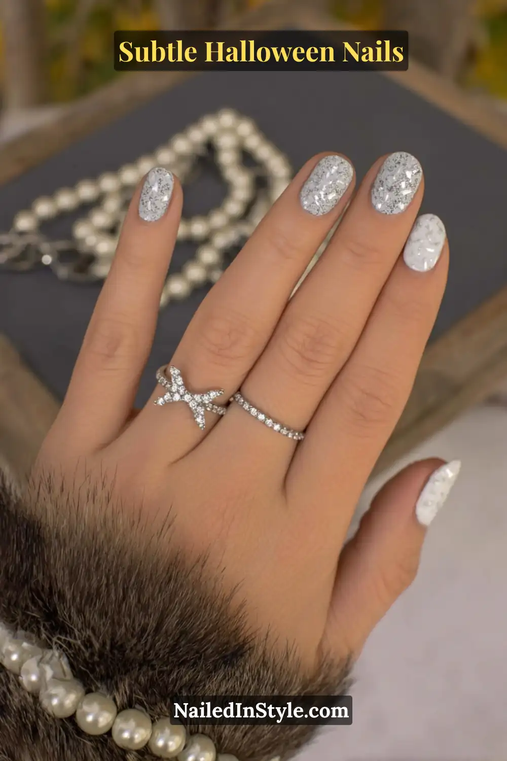 Subtle Halloween Nails: Medium oval nails in soft ivory and ash tones, layered with frosted petal art and delicate micro pearls for a 3D texture that catches the light with every movement. Styled with pearl jewelry for a luxurious, ethereal Halloween finish.