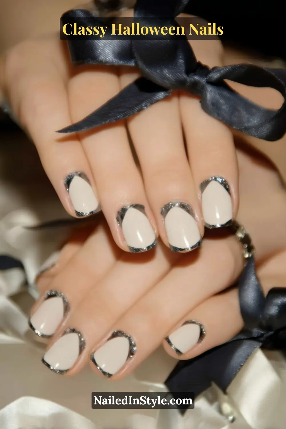 Short square nails in soft opal beige encased by a razor-thin raven and pewter metallic micro frame — a sleek, sculpted French style that feels tailored and timeless.