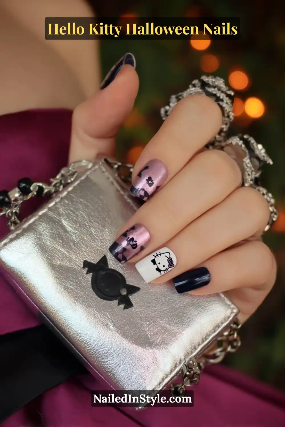 Short square nails painted in glossy black and metallic magenta, featuring a single white accent nail with a Hello Kitty decal and soft lace detail. Styled with a silver clutch for a perfect balance of edgy and adorable Halloween style.