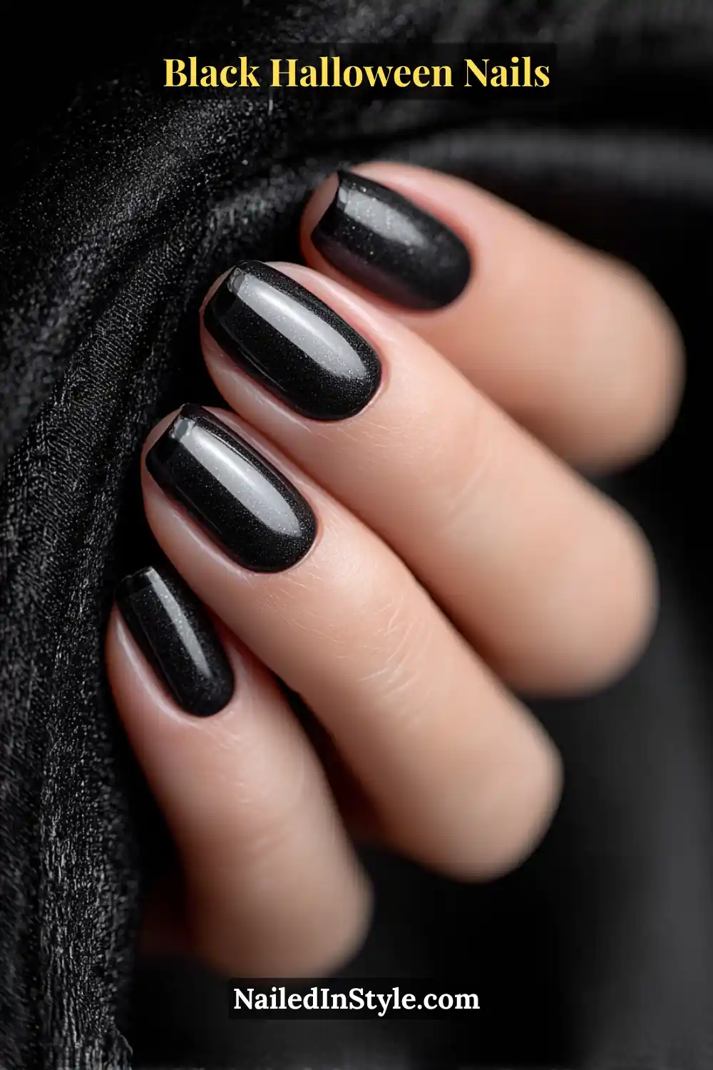 Long soft coffin nails in deep jet black with ultra-thin graphite crescents lining the free edges; smooth glossy finish with a refined gleam, styled against a black velvet fabric.
