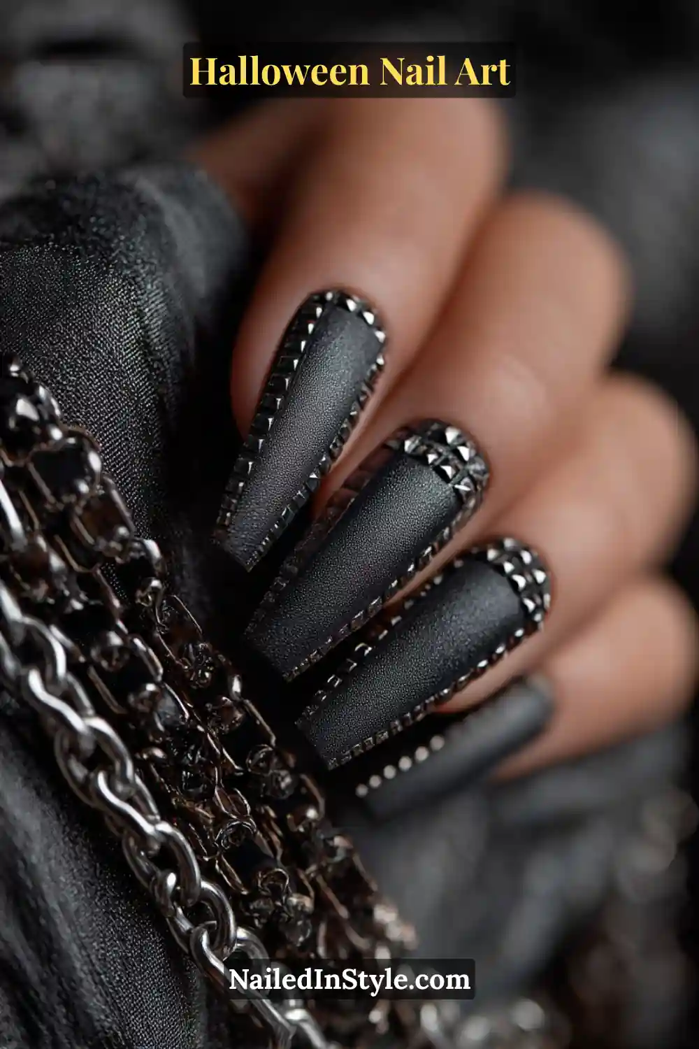 Long coffin nails in matte gunmetal gray with tiny 3D rivet studs outlining each nail edge, creating an edgy Halloween-inspired industrial look.