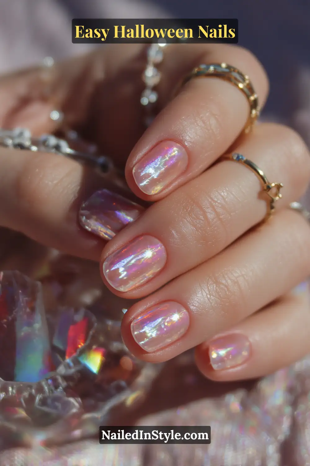 Oval nails in a translucent pink base with a single holographic vertical line and a pinpoint star accent, finished with a high-gloss iridescent shine for Easy Halloween Nails.