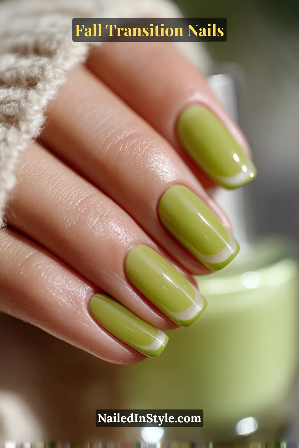 Medium squoval nails in a glossy honeydew green outlined frame design with a clear center, styled against a cozy linen sweater for a fresh fall look.