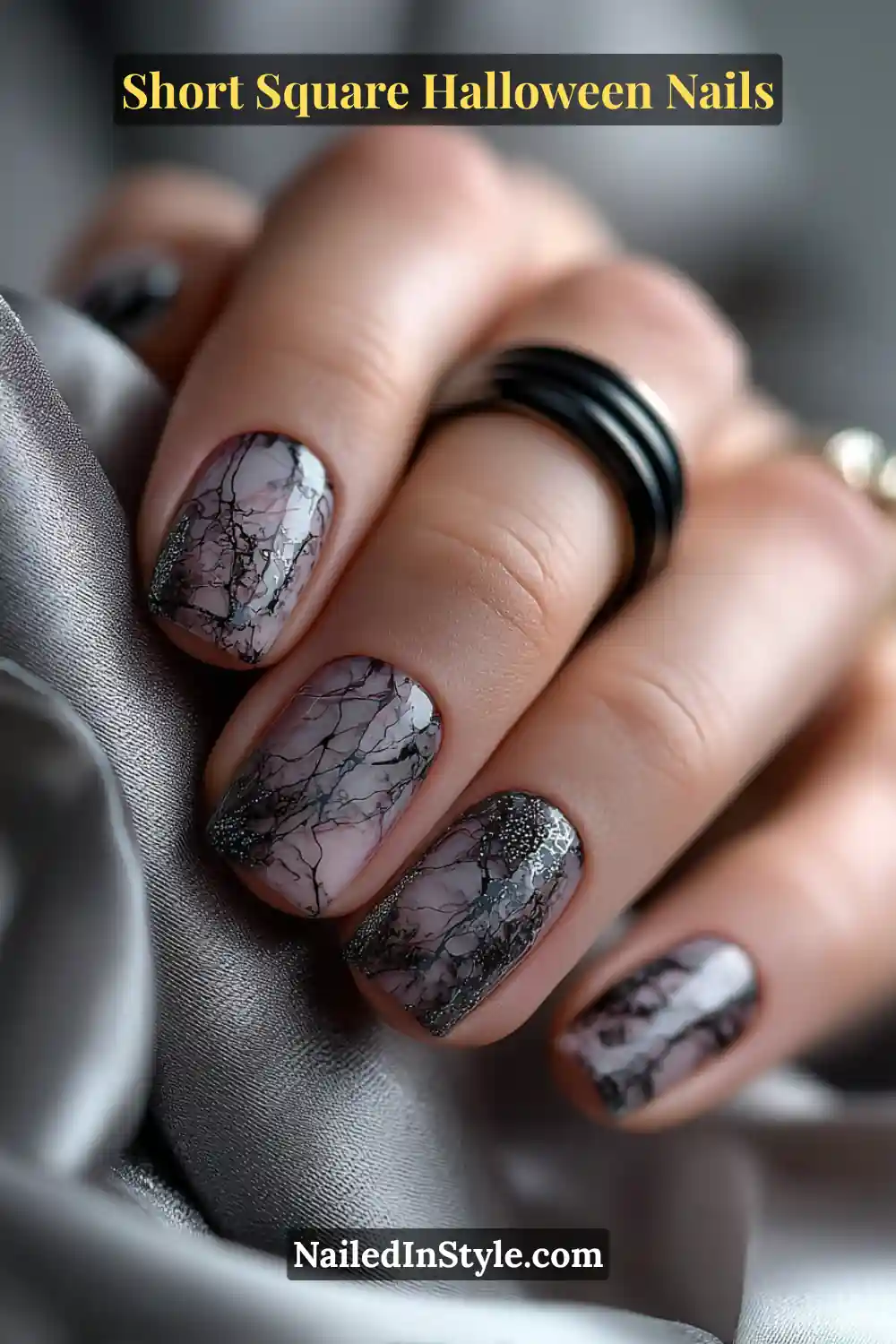 Short square nails with delicate black spider-web line art over a nude base, creating a sleek and minimal Halloween nail look.
