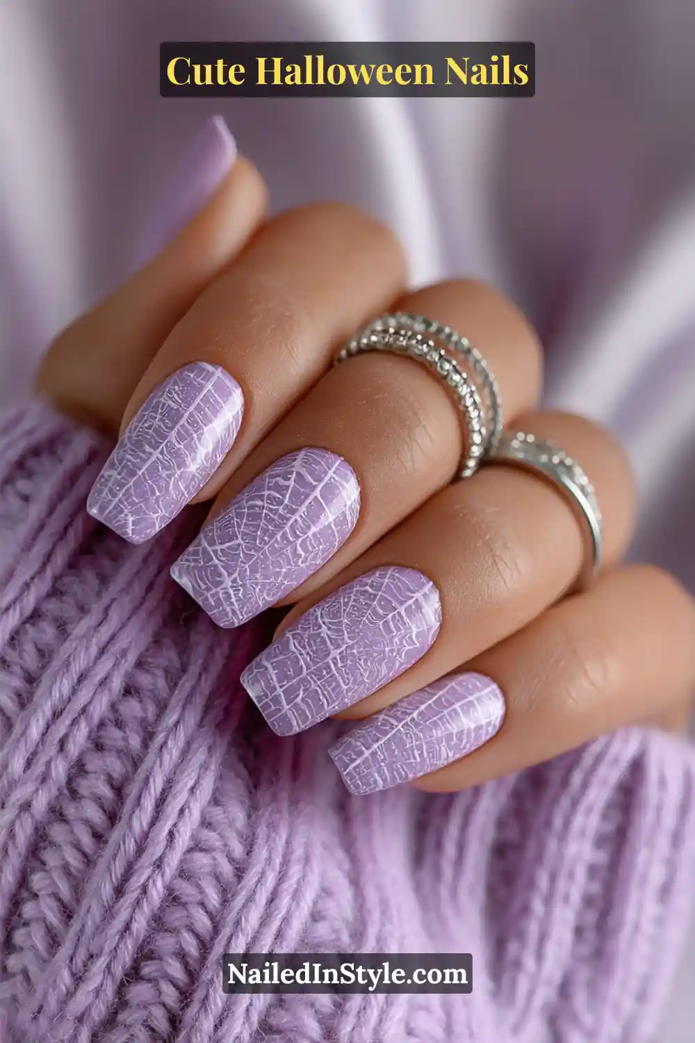 Cute Halloween nails in soft lavender with delicate web line detailing at the corner, featuring a glossy finish and long square shape.