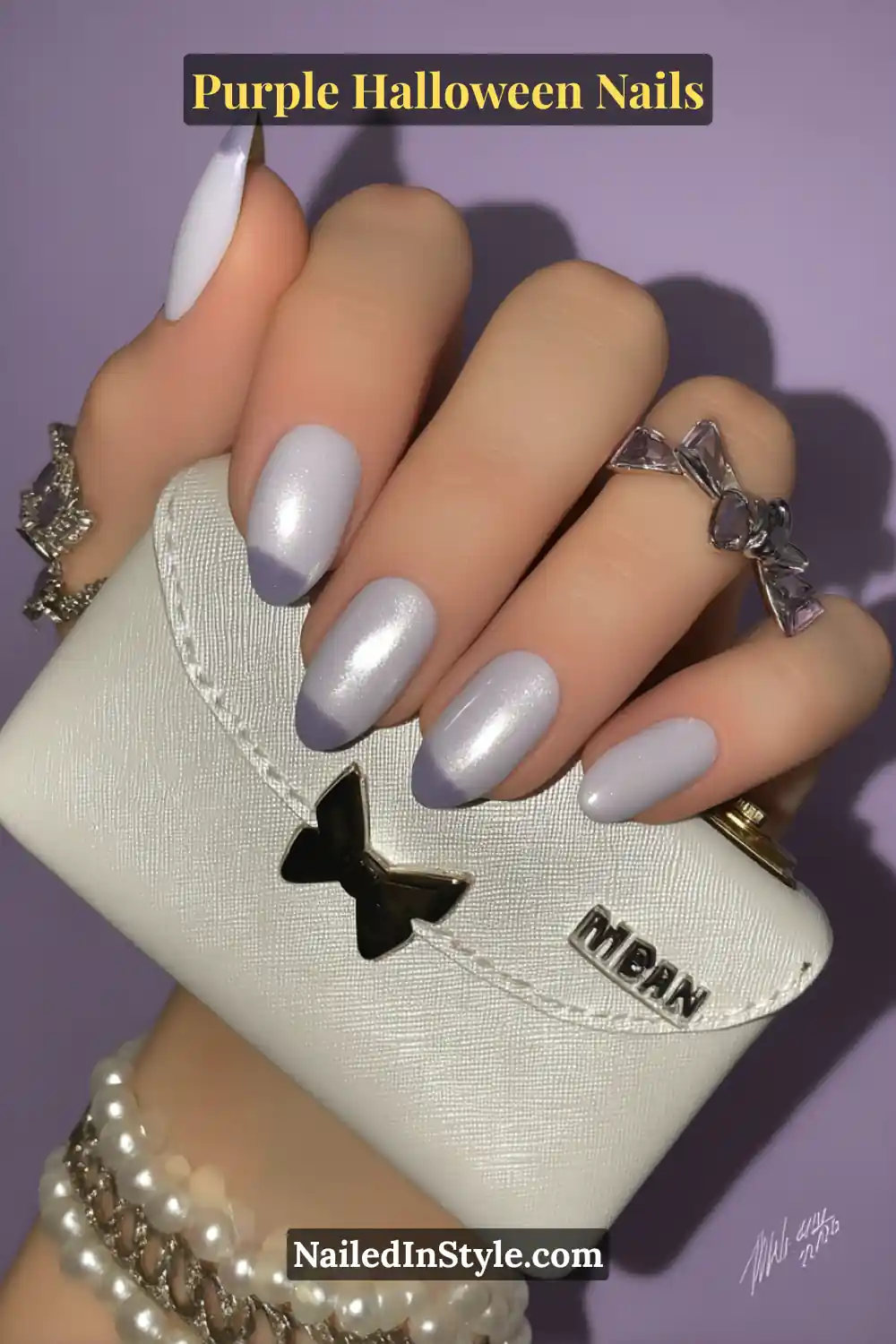 Short squoval nails with a soft lilac base and frosted chrome French tips, creating a polished and icy lavender look perfect for a classy Halloween vibe.