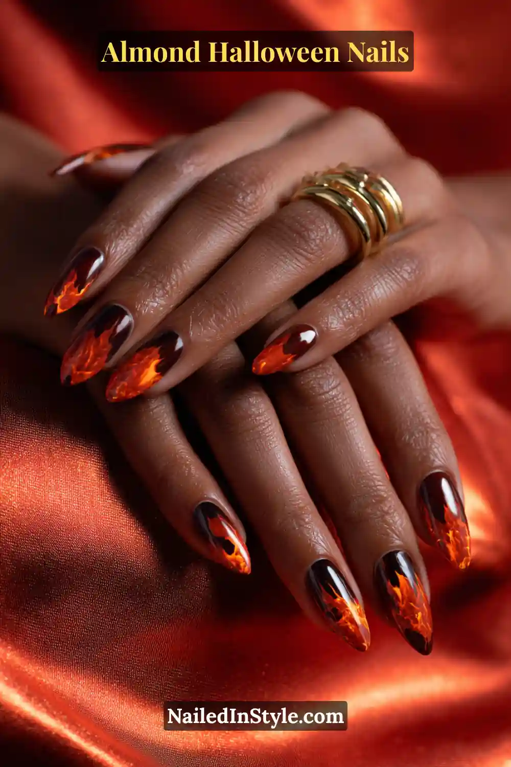 Close-up almond nails with deep espresso base and sculpted molten orange flame tips in glossy 3D finish, reflecting fiery metallic tones, Almond Halloween Nails.