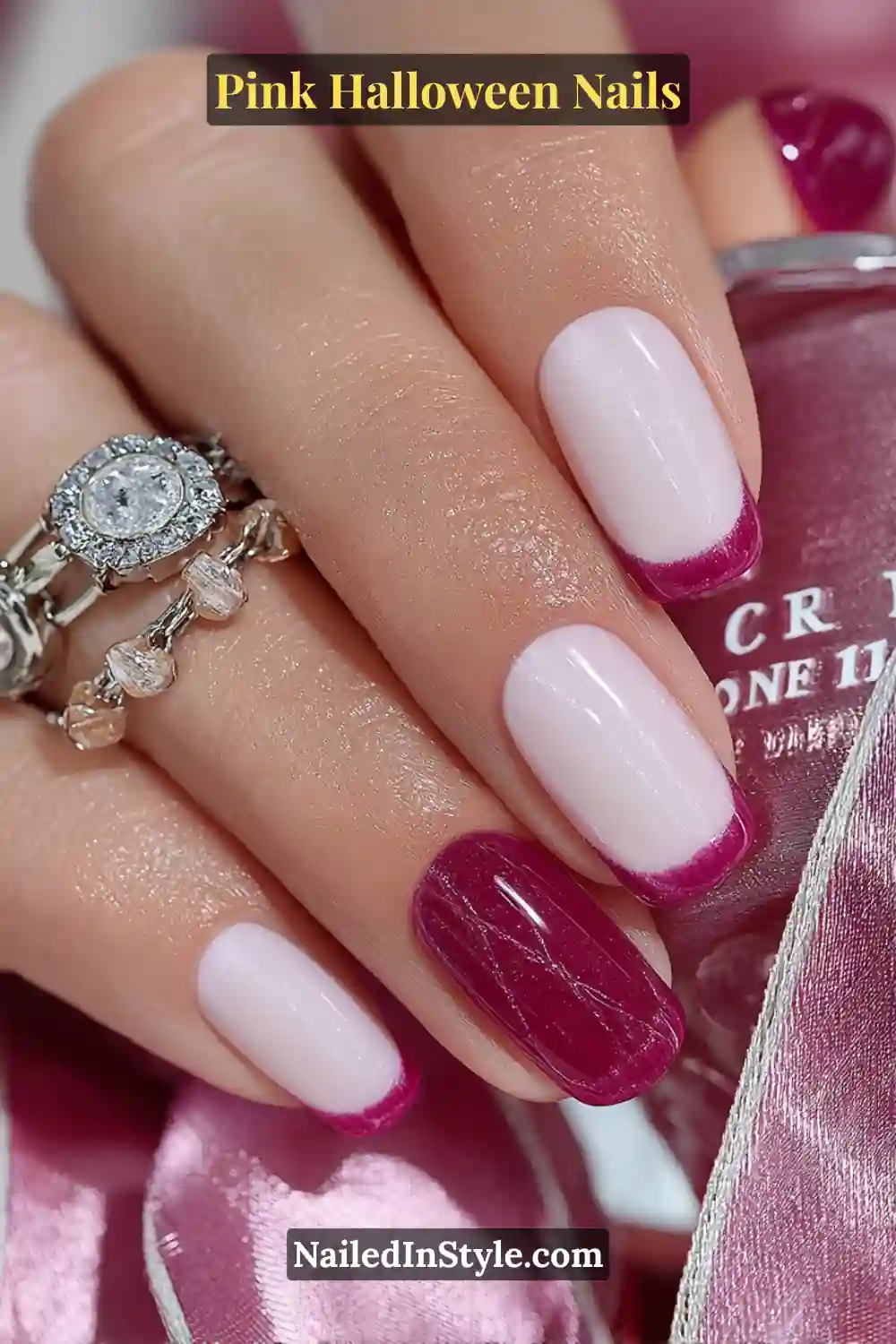 Pink Halloween nails with marshmallow white base and ultra-thin magenta French tips, featuring a tiny 3D heart-web accent and styled with a satin ribbon.