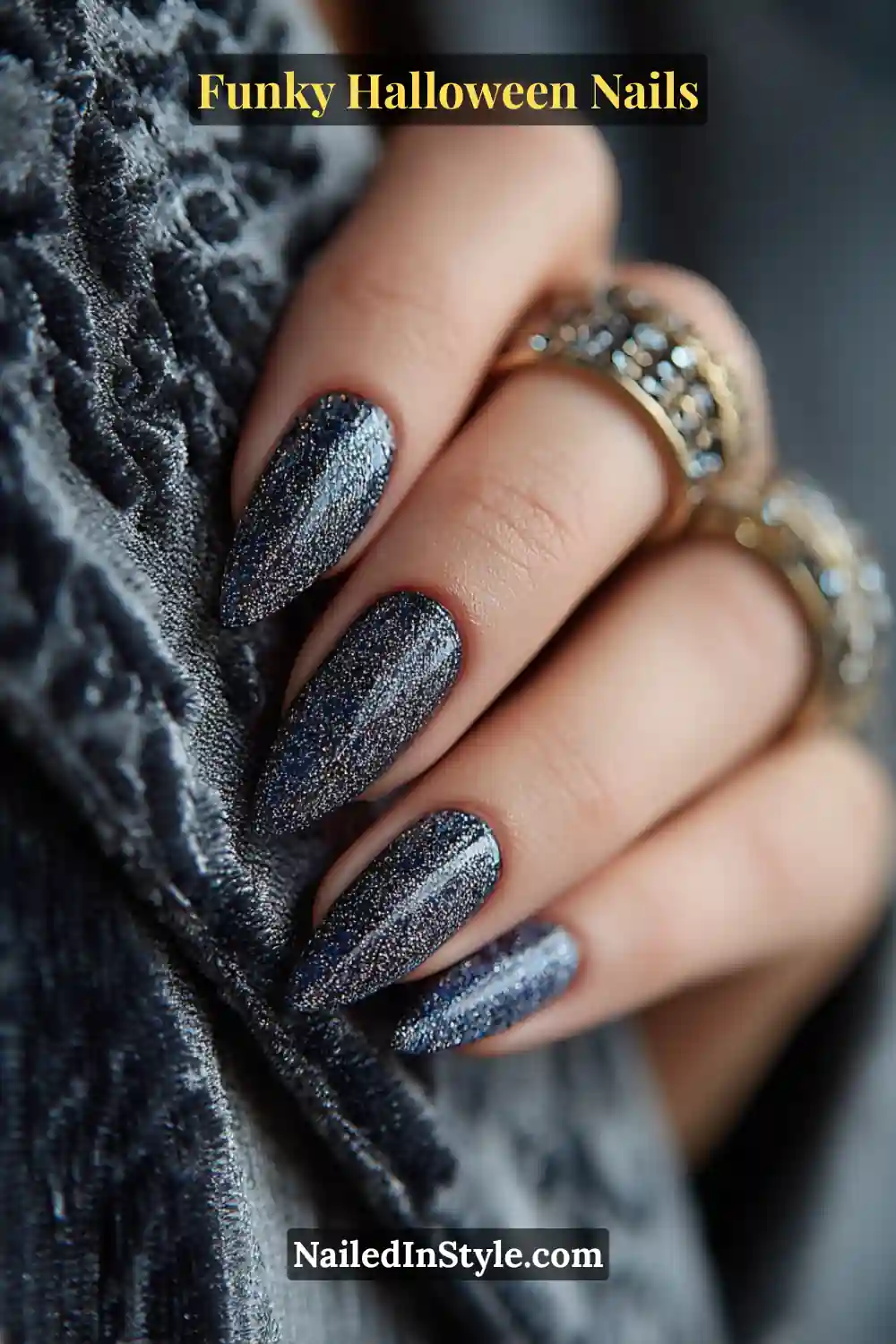 Medium almond nails in midnight, pewter, and navy tones featuring a sheer smoky glitter haze framed with a soft matte rim, styled with a velvet jacket for celestial Halloween allure.