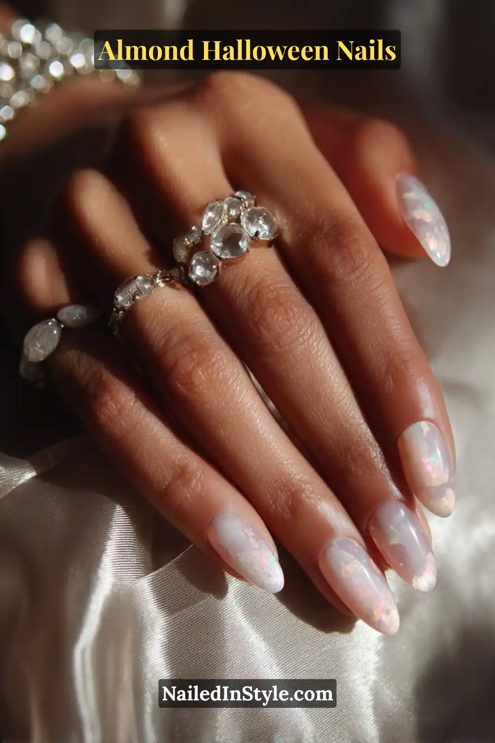 Close-up almond nails with sheer charcoal jelly base and embedded opal pigment swirls, creating pearlescent smoke movement under gloss, Almond Halloween Nails.