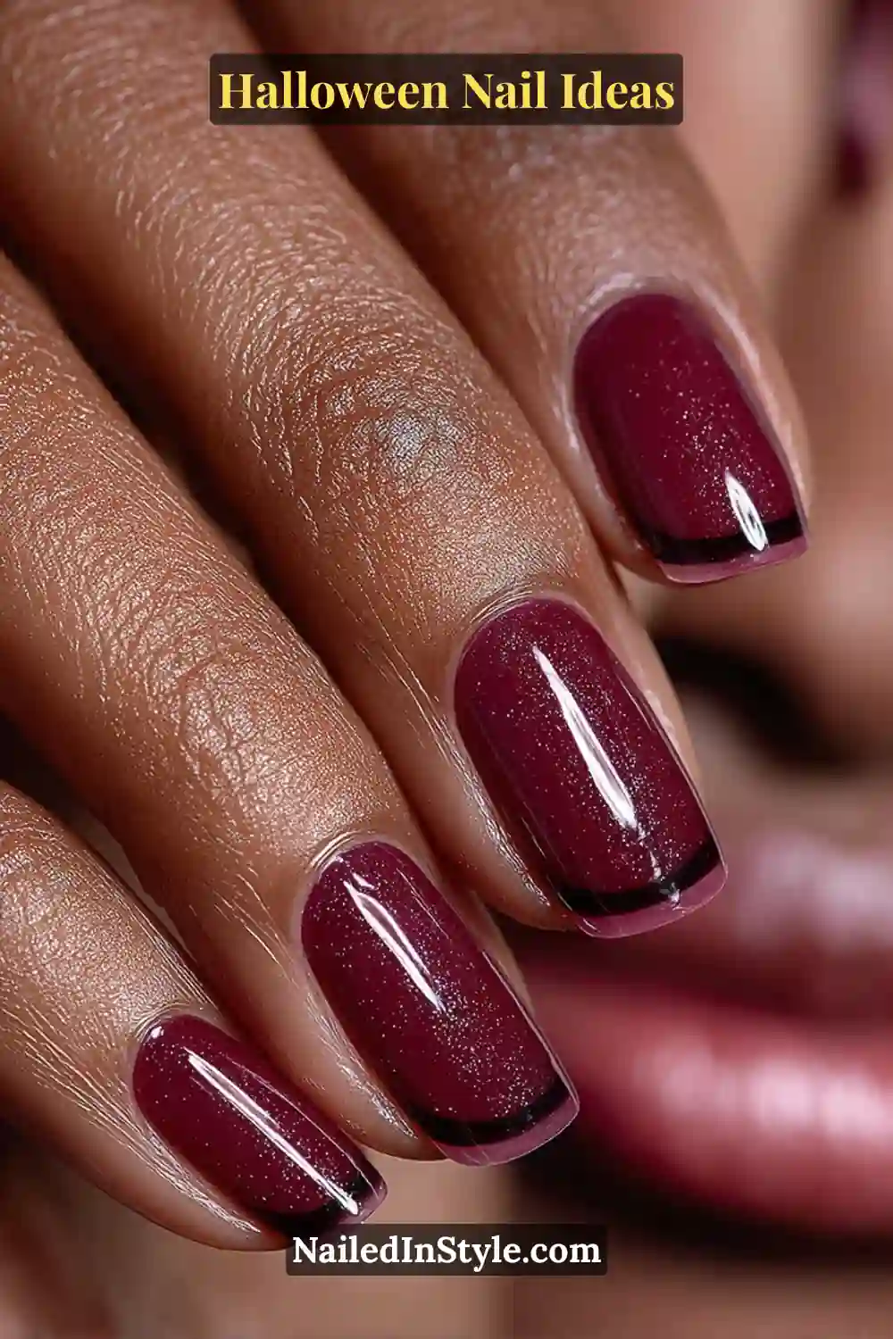 Long ballerina nails in rich oxblood red with a high-gloss finish and razor-thin black French tips; styled with deep berry tones and a patent mini bag for a bold Halloween look.