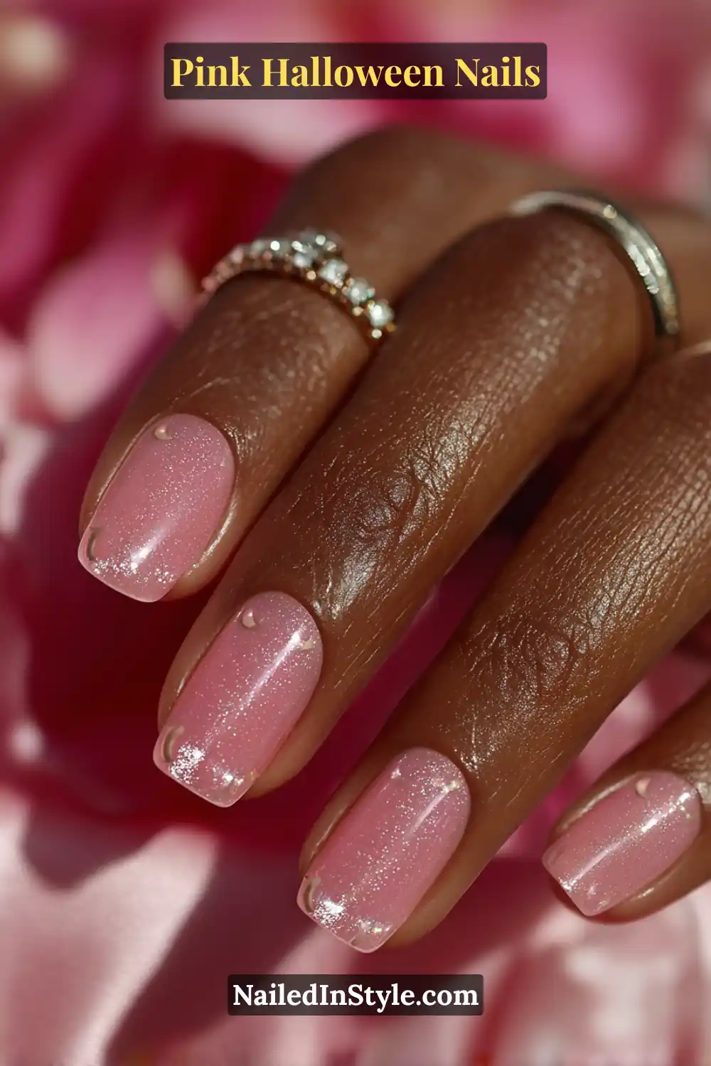 Pink Halloween nails with a sheer peony jelly base and tiny 3D chrome crescent moon accents near the tips, in a medium almond shape, styled with a pendant necklace.