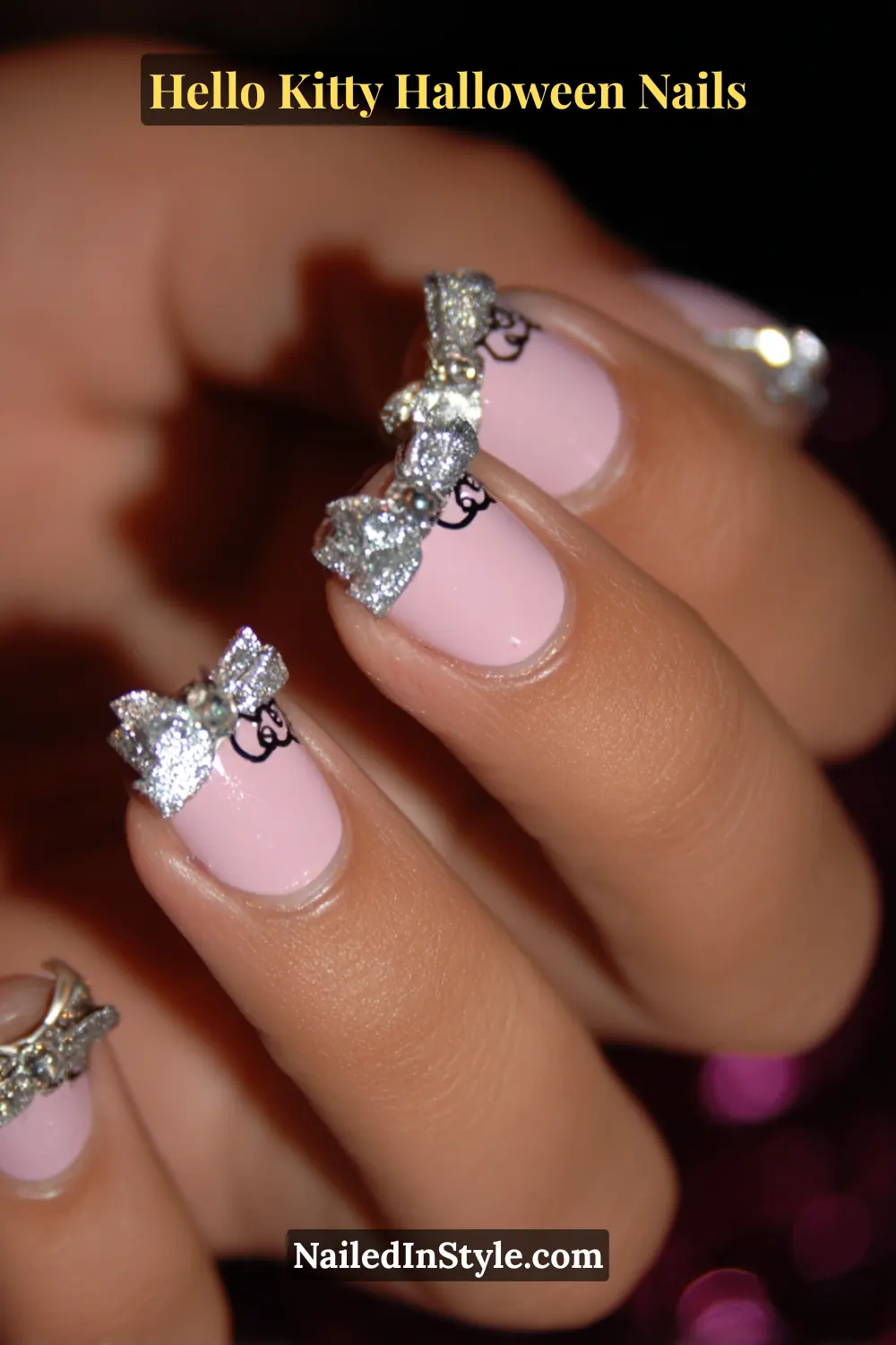 Short square nails painted in glossy bubblegum pink with delicate silver micro-French tips and 3D satin bows near the cuticle, blending playful charm with luxe detailing. A perfect mix of sweet and spooky for Hello Kitty Halloween nails.