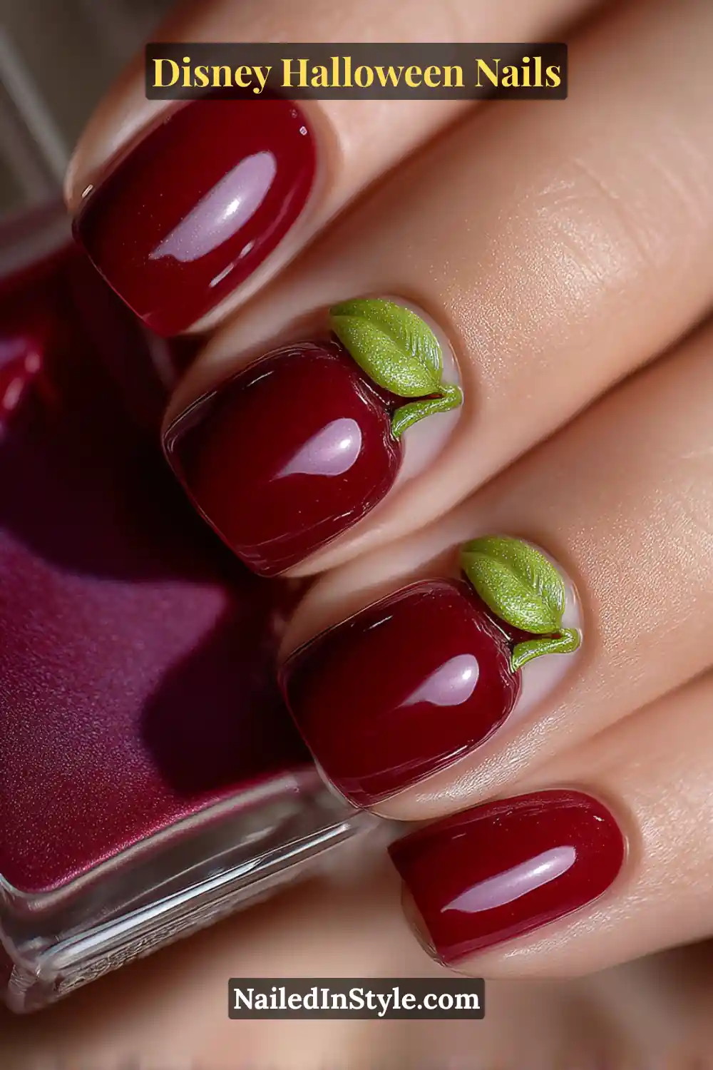 Short square nails coated in glossy ruby red with tiny 3D green leaves sculpted at the base, creating a playful poison-apple illusion; paired with a mirrored phone case for a modern Disney villain vibe.