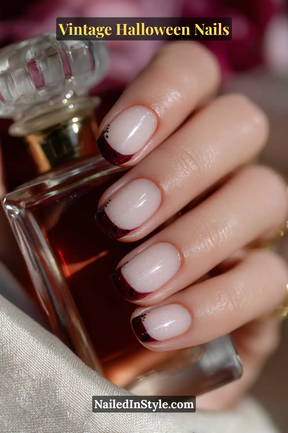 Short square nails featuring a soft parchment base with oxblood micro-French tips and tiny onyx pin dots near the cuticle for a refined, vintage Halloween effect.