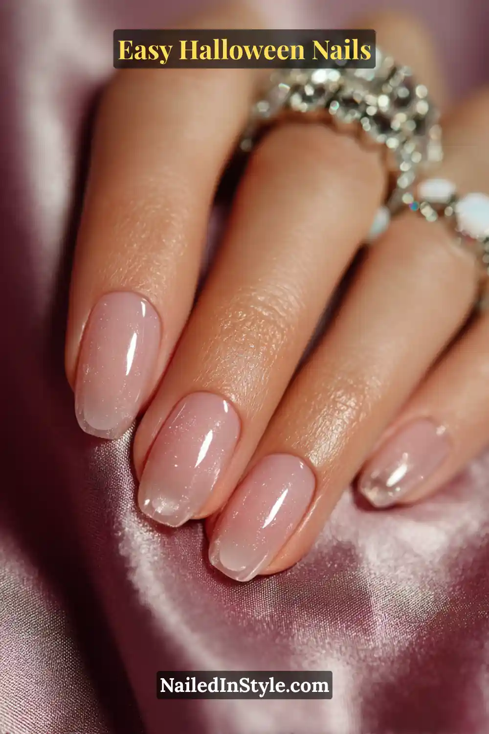 Short oval nails with a translucent pink glossy base featuring three clear sculpted bubble domes near the cuticle, creating a soft, dimensional glow for Easy Halloween Nails.