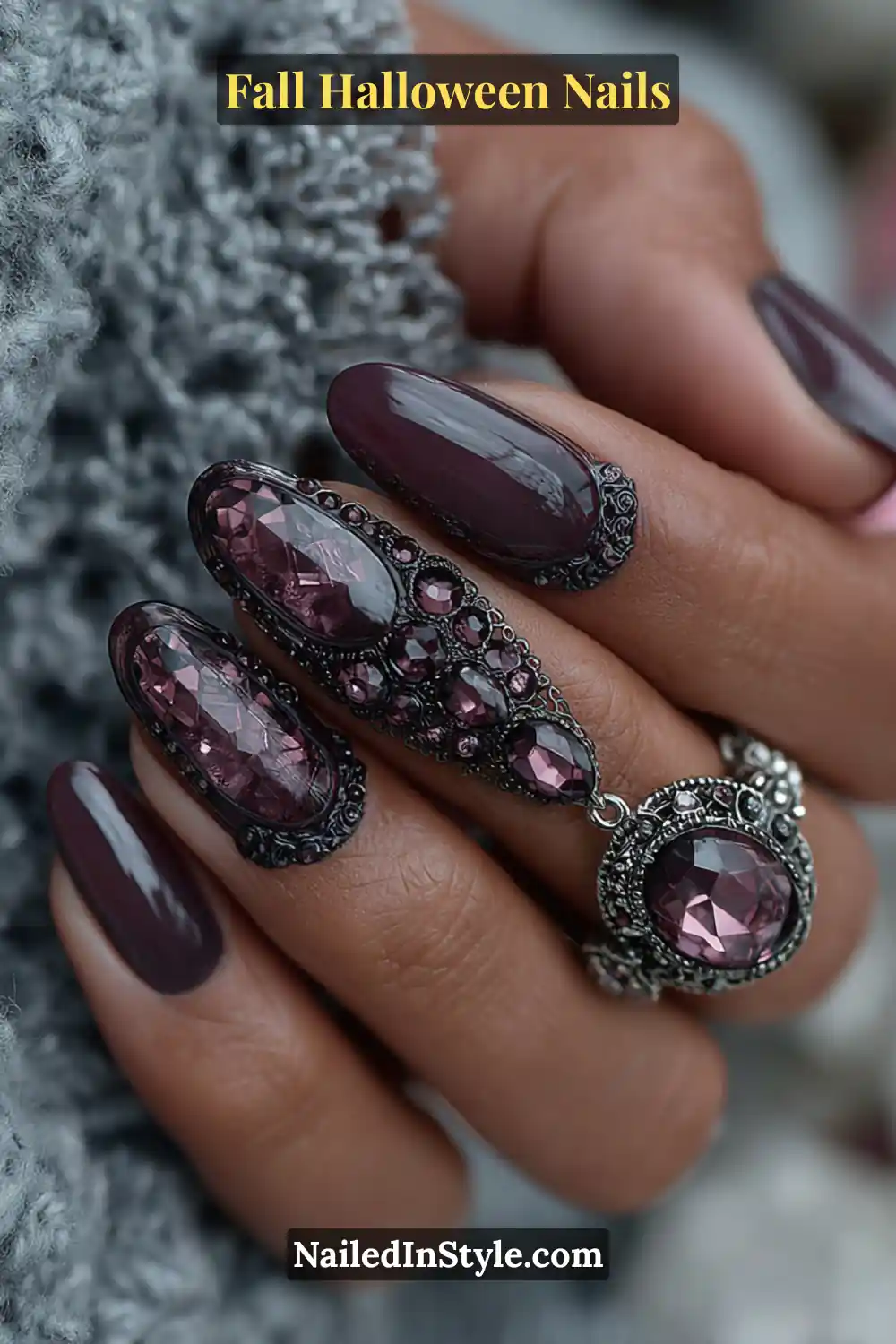 Medium almond nails cloaked in a sheer plum veil layered over a dark raven base, accented with jewel-toned crystals and gothic silver rings for a moody, opulent finish.