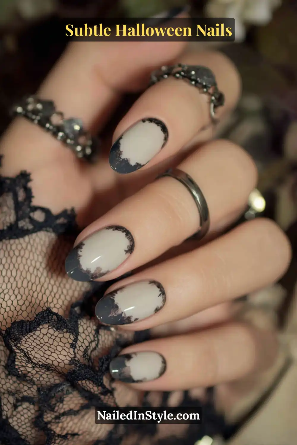 Medium oval nails featuring a porcelain base with crescent fades of graphite smoke near the cuticle, finished with a high-gloss overlay. Styled with a chrome ring and lace details for an elegant, shadowy Halloween aesthetic.