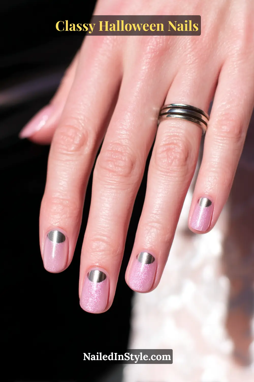Short square nails with a sheer blush base topped by raised metallic silver half-moons, creating a sleek 3D contrast that feels both polished and fashionably futuristic.