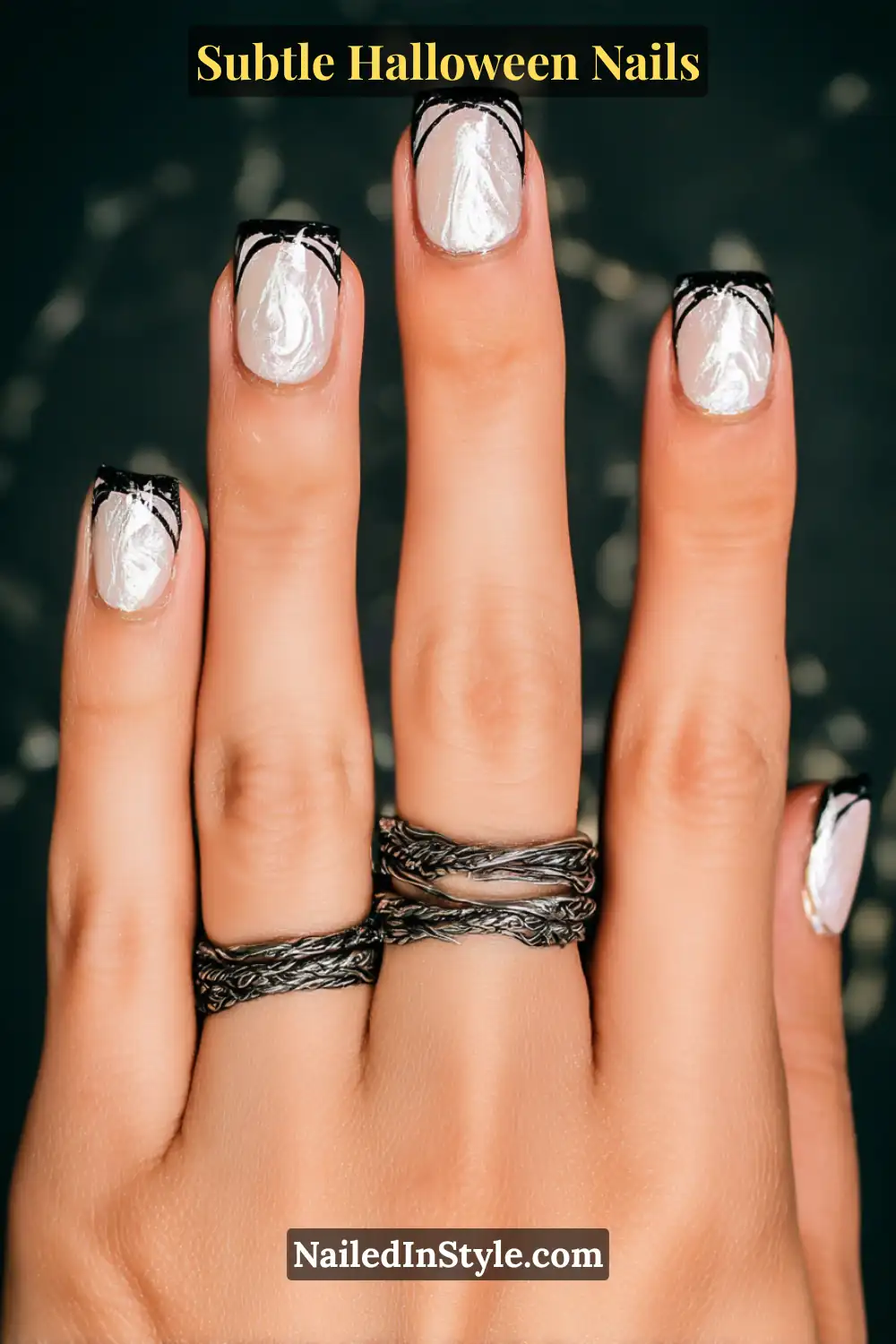 Short square nails with a sheer pearl base and delicate silver micro-French tips, finished with a single chrome dot accent for a 3D glint. The look balances quiet sophistication and festive shimmer against soft, natural skin tones.