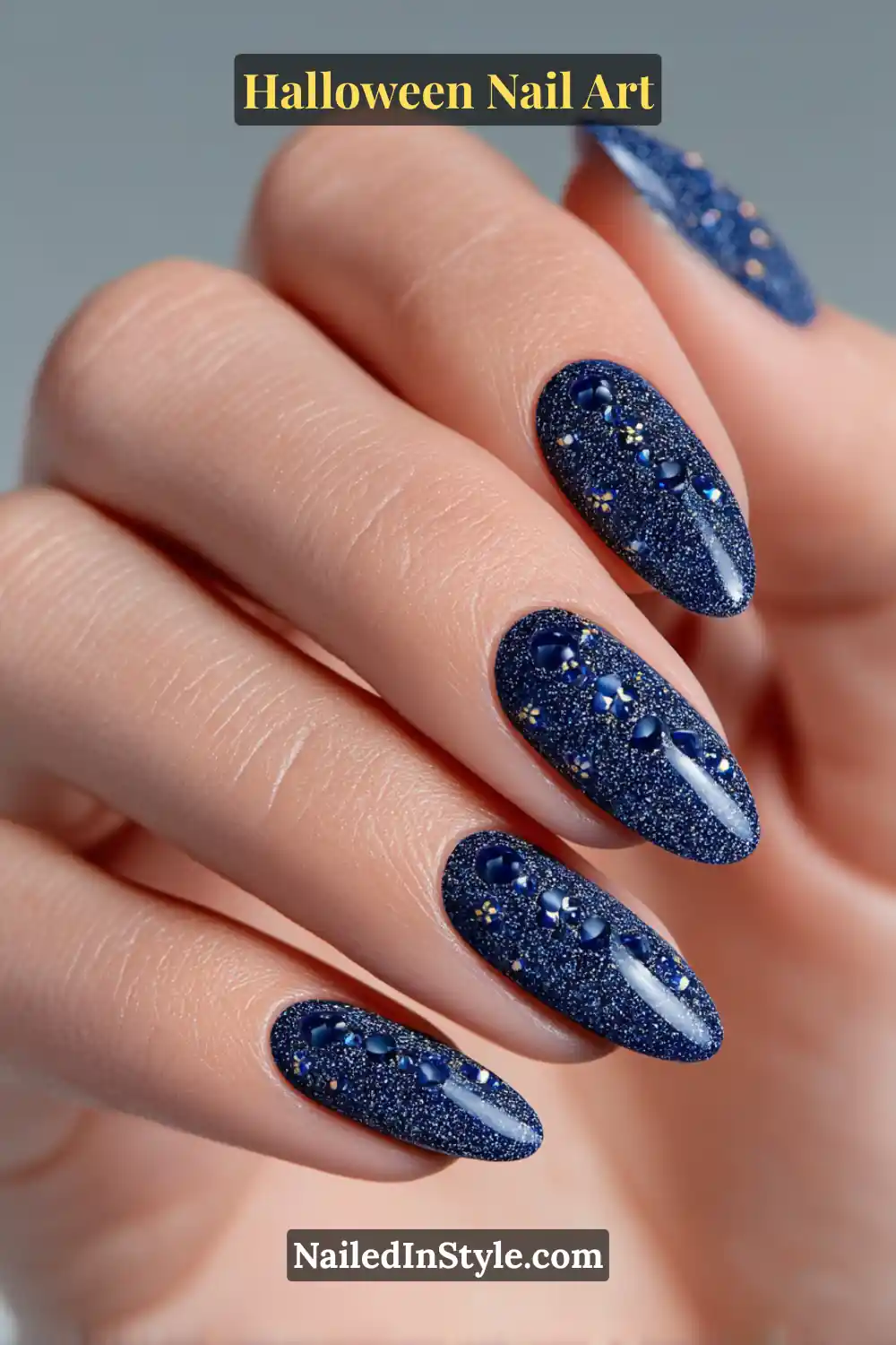 Medium almond nails in midnight navy with fine shimmer and raised opal cabochons forming a starry trail; paired with a mirrored phone case for a chic cosmic vibe.
